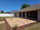 View of the brick paved patio featuring a pergola, perfect for shaded relaxation in the backyard at 107 Amber Blvd, Auburndale, FL 33823