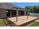 A brick patio under a pergola offers a cozy outdoor seating space in this backyard at 107 Amber Blvd, Auburndale, FL 33823