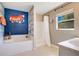 Bathroom featuring a soaking tub with decorative wall art, walk-in shower, and natural light at 107 Amber Blvd, Auburndale, FL 33823