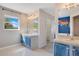 Bright bathroom featuring blue vanity, large mirror, and a window providing natural light at 107 Amber Blvd, Auburndale, FL 33823