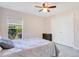 Cozy bedroom features wood-look flooring, ceiling fan and window views at 107 Amber Blvd, Auburndale, FL 33823