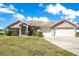 Charming single-story home featuring a two-car garage, well-manicured lawn, and delightful landscaping at 107 Amber Blvd, Auburndale, FL 33823