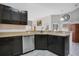 Kitchen featuring stainless steel dishwasher, dark cabinetry and views to other living spaces at 107 Amber Blvd, Auburndale, FL 33823