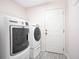 Convenient laundry room includes modern washer, dryer, and wire shelving at 107 Amber Blvd, Auburndale, FL 33823