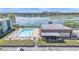 Aerial view of condo complex pool, patio furniture, and surrounding lake at 1130 N Lake Parker Ave # C328, Lakeland, FL 33805