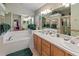 Bathroom with a large mirror reflecting the soaking tub and double sink vanity at 117 Belmont Dr, Winter Haven, FL 33884