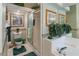 Well-lit bathroom featuring a tiled shower, soaking tub, and floral wallpaper at 117 Belmont Dr, Winter Haven, FL 33884