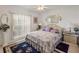 Bedroom featuring a large window, patterned rug, and bedside tables with lamps at 117 Belmont Dr, Winter Haven, FL 33884