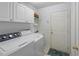 Laundry room with washer, dryer, cabinets, and a utility sink at 117 Belmont Dr, Winter Haven, FL 33884