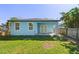 Back exterior with windows and glass paneled door, covered porch, and lush green lawn at 127 Florida Dr, Winter Haven, FL 33881