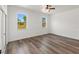 Light-filled bedroom featuring wood floors, two windows and fresh paint at 127 Florida Dr, Winter Haven, FL 33881