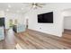 Open-concept living room features a large flatscreen television, ceiling fan, and hardwood flooring at 127 Florida Dr, Winter Haven, FL 33881