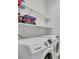 Well-equipped laundry area features modern Samsung washer and dryer with built-in shelving, offering ample space at 1298 Zeek Ridge St, Clermont, FL 34715