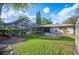 A verdant backyard featuring a screened-in pool, manicured landscaping, and a comfortable patio area at 1311 Glengreen Ln, Lakeland, FL 33813