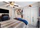 Comfortable bedroom with a ceiling fan, television, and built-in shelving for storage at 1311 Glengreen Ln, Lakeland, FL 33813