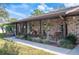 Charming brick home featuring a covered front porch, rocking chairs, plants, and a swing at 1311 Glengreen Ln, Lakeland, FL 33813