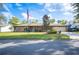 Charming single-story brick home featuring an American flag, well-manicured lawn, and an attached two-car garage at 1311 Glengreen Ln, Lakeland, FL 33813