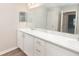 Bathroom featuring double vanity, marble countertops, modern mirrors, and ample storage at 1327 Mottled Duck Ln, Lakeland, FL 33811