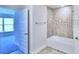 Bright bathroom features a shower over the tub with tile surround and open doorway to an adjacent bedroom at 1588 Leamington Ln, Winter Haven, FL 33884