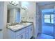 Bathroom with double sink vanity and framed mirror, and an open doorway into an adjacent room at 1588 Leamington Ln, Winter Haven, FL 33884