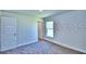 Bedroom features a neutral color palette, large windows, and a door leading to the hallway at 1588 Leamington Ln, Winter Haven, FL 33884