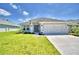 Charming single-story home with a well-manicured lawn and a long driveway leading to an attached garage at 1588 Leamington Ln, Winter Haven, FL 33884