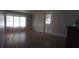 Spacious living room features hardwood floors, a bright window, and a glass-paneled door at 1610 Reynolds Rd # 239, Lakeland, FL 33801