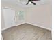 Bedroom featuring wood-look flooring, natural light from the window, and neutral color palette at 1714 2Nd Ne St, Winter Haven, FL 33881