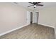 Spacious bedroom featuring wood-look flooring, a ceiling fan, and neutral color palette at 1714 2Nd Ne St, Winter Haven, FL 33881