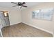 Bright bedroom boasts wood-look floors, a ceiling fan, and natural light from the window at 1714 2Nd Ne St, Winter Haven, FL 33881