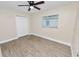 This bedroom features wood-look floors, a ceiling fan, a window with blinds and a closet at 1714 2Nd Ne St, Winter Haven, FL 33881