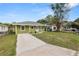 Quaint single-Gathering home with a concrete driveway, green grass and mature trees in the front yard at 1714 2Nd Ne St, Winter Haven, FL 33881