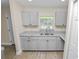 Well-lit kitchen featuring sleek cabinets, granite countertops and stainless steel sink at 1714 2Nd Ne St, Winter Haven, FL 33881