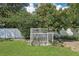 A white chicken coop sits in the grassy backyard at 1722 High Point Dr, Lakeland, FL 33813