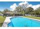 Backyard with a large pool, tropical greenery, and patio at 1722 High Point Dr, Lakeland, FL 33813