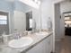 Bathroom features a double sink vanity with granite countertops and a large mirror at 1728 Burrows Ave, Lakeland, FL 33811