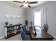 Well-lit home office space features a dark wood desk, ceiling fan and a decorative shelving unit at 1728 Burrows Ave, Lakeland, FL 33811