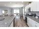 Bright kitchen featuring white cabinets, granite countertops, stainless steel appliances, and hardwood floors at 1728 Burrows Ave, Lakeland, FL 33811