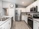 A modern kitchen featuring stainless steel appliances, sleek countertops, and white cabinets at 1740 Burrows Ave, Lakeland, FL 33811