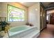 Elegant bathroom featuring a bathtub with decorative tile surround and stained glass window at 1842 Pinnacle Dr, Lakeland, FL 33813