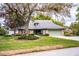 A well-maintained home with stone accents, a green lawn, and mature trees enhancing curb appeal at 1842 Pinnacle Dr, Lakeland, FL 33813