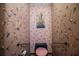 Small toilet room featuring floral wallpaper, safety bars, and a vintage wall painting at 1842 Pinnacle Dr, Lakeland, FL 33813