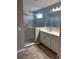 Modern bathroom featuring a glass enclosed shower with tile surround, a large mirror, and double sink vanity at 1921 Bell Creek Loop, Fruitland Park, FL 34731