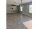 Spacious living room with wood-style tile flooring, modern lighting fixtures, and bright windows at 1921 Bell Creek Loop, Fruitland Park, FL 34731