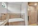 Well-lit bathroom featuring a soaking tub, a tiled shower, and a marble counter at 2030 Country Manor St, Bartow, FL 33830