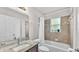 Bright bathroom featuring a granite vanity top, tub, decorative tile accents, and natural light at 2030 Country Manor St, Bartow, FL 33830