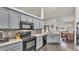 Bright kitchen featuring gray cabinets, stainless steel appliances, and a view to the dining and living areas at 2030 Country Manor St, Bartow, FL 33830