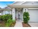 Cozy front entrance with a tiled walkway, well-kept garden and an attached two-car garage at 2085 Pecos Dr, Kissimmee, FL 34759