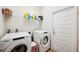 Bright laundry room with white washer, dryer, shelving, and ample storage space at 2085 Pecos Dr, Kissimmee, FL 34759