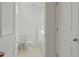 All-white bathroom with a toilet, tiled floor, and a shower curtain over the tub at 2210 Moraine Ct, Lakeland, FL 33805